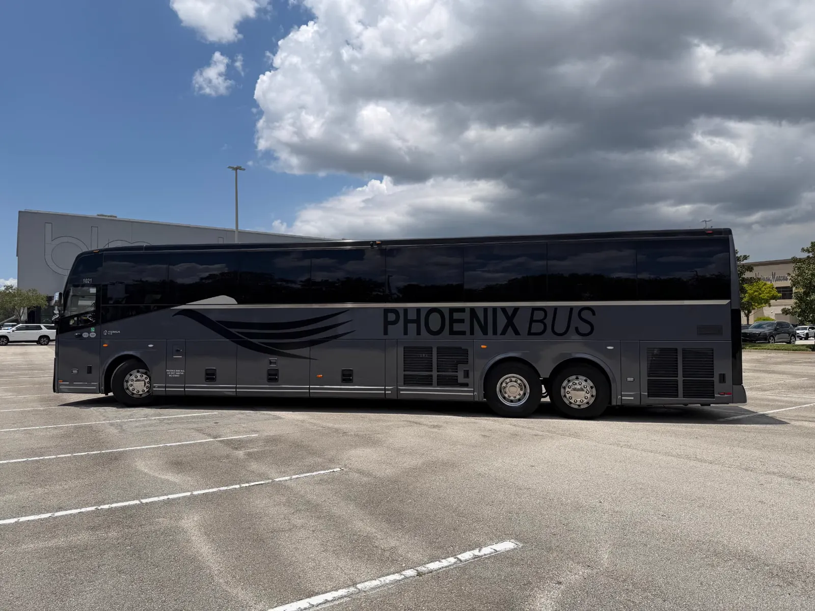 Temsa motorcoach operated by Phoenix Bus Orlando loading passengers on the ring road at The Mall at Millenia, Orlando