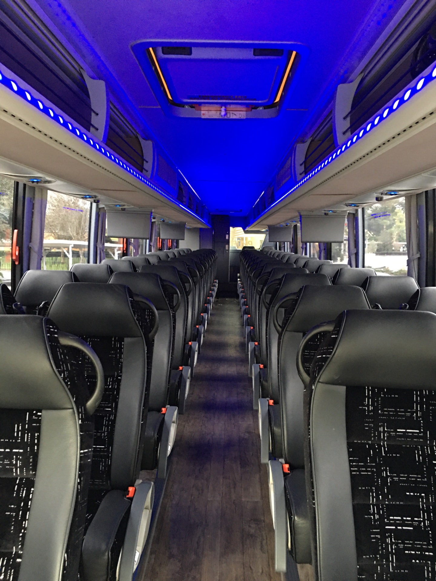 Motorcoach interior with executive blue LED cabin lighting, reclining seats and 3-point seat belts