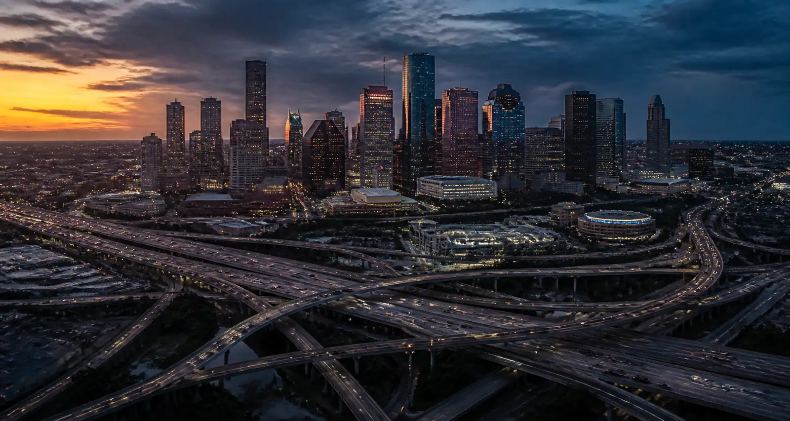 Aerial view of the Downtown Houston skyline and freeway interchange at dusk